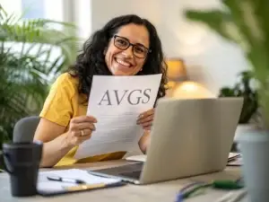 Sinnbild für AVGS beantragen beim gründungs.center: Eine Frau mit dunklem Haar und Brille sitzt lächelnd an einem Tisch in einem modernen Büro. Vor ihr liegen ein Laptop, eine Kaffeetasse und ein Blatt Papier mit der Aufschrift ‚AVGS‘. Im Hintergrund sind grüne Pflanzen unscharf zu sehen. Die Szene wirkt professionell, einladend und warm.