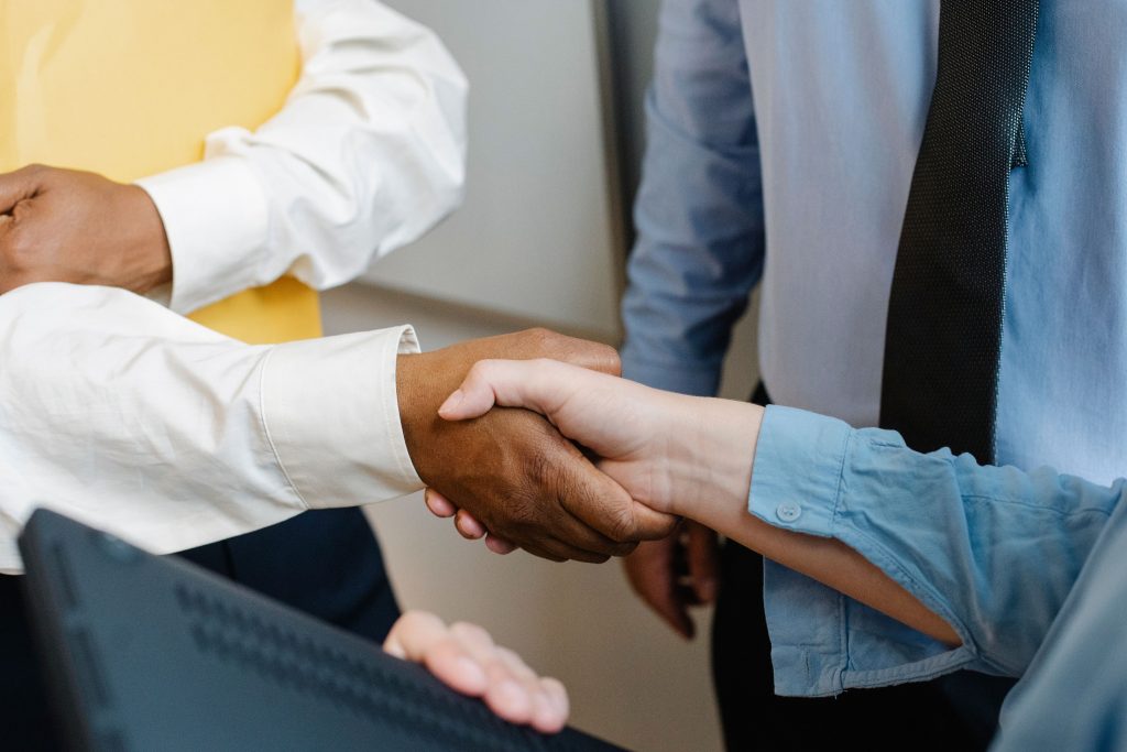 Sinnbild Gründen aus der Kündigung: Händedruck im Businesskontext